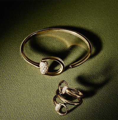 Image of gucci horsebit jewellery on green background. tap to shop all gucci jewellery image