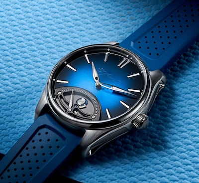 H.Moser Blue Dial Watch on blue background. Tap to shop all H.Moser & Cie image