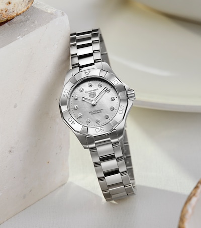 Image of tag heuer watch in cream ceramic dish. tap to shop all ladies watches image