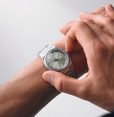 Image of mens' hand wearing Raymond Weild silver dial watch image